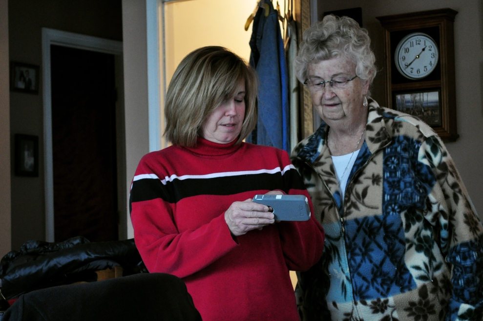 Mary Duval, shows a photo to Judy Thompson of Brennen, the newsest addition to the family. Brennen was born two weeks ago but Judy can't remember who he is, no matter how often she's shown the photos.